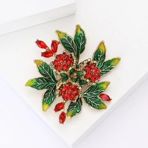 Elegant gold metal rose brooch with red crystals and green enamel floral accents