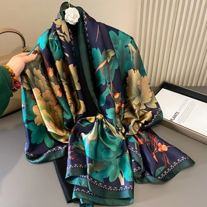 Detailed view of dark blue silk scarf with gold peony floral pattern and elegant drape