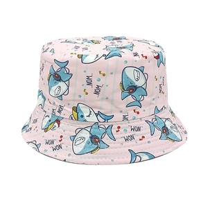 Detailed close-up of pink bucket hat with cute cartoon shark and music note patterns