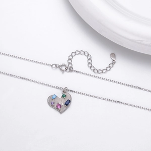 Close-up of S925 sterling silver heart pendant with colorful zircon stones and brushed texture