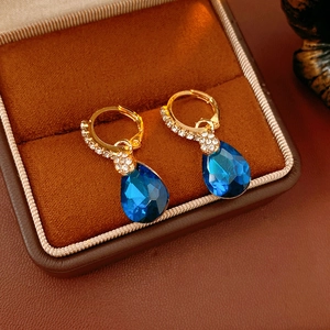 Détails de créoles dorées ornées de strass et de breloques en cristal bleu en goutte