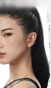 Close-up of zircon paved ear cuff and silver textured ear clip worn on a female ear