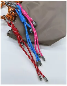 Close-up of colorful braided climbing rope keychains with metal carabiners on a bag