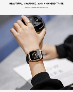 Elegant gold square quartz watch with black silicone strap worn by a lady holding coffee
