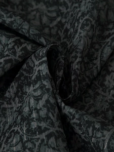 Detail of dark grey fabric with black paisley print and vertical silver metallic lurex stripes