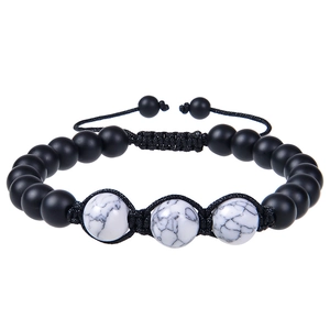 Detailed close-up of matte black beads and white turquoise on adjustable braided bracelet