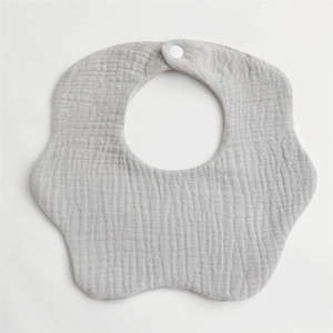 Detail of grey muslin cotton baby bib with petal shape edges and white snap closure