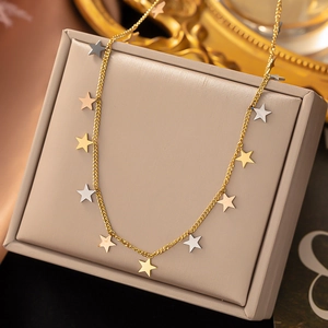 Macro shot of titanium steel necklace with gold, silver, and rose gold star pendants