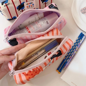 Détail de trousses à crayons en toile aux motifs de chat et lapin avec fermeture éclair