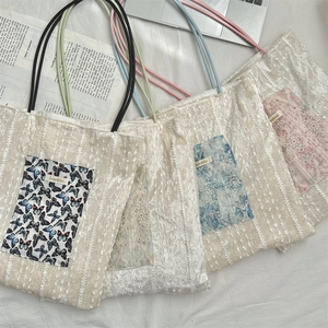 Flat lay of lace tote bags with colored rope handles and butterfly prints on magazine