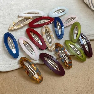 Oval acetate hair clips in multiple colors featuring elegant marble and amber patterns