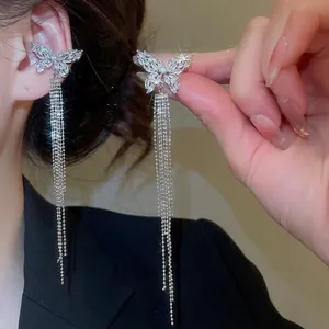 Elegant silver butterfly tassel earrings with zircon pave on dark suit background