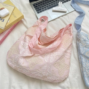 Detail of pink satin hobo bag featuring 3D butterfly embroidery and spacious design