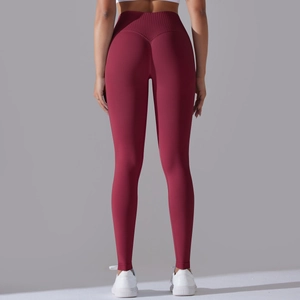 Detail showing the seamless ribbed high waist and V-shaped back seam of dark red yoga pants