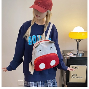 Detailed side view of the cute cow canvas backpack for toddlers on a model