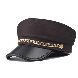 Detail of British style newsboy hat with black PU leather brim and gold chain accent