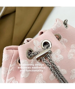 Detailed close-up of pink bucket bag with 3D floral jacquard and silver chain drawstring