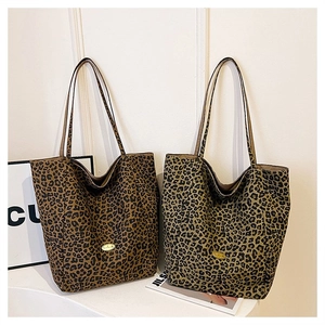 Detailed view of leopard print tote bags in dark and light tones with gold logo plate