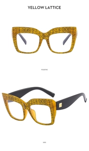 Detail of yellow lattice oversized cat eye glasses with black temples and gold metal buckle