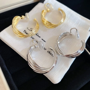 Detailed macro of twisted metal hoop earrings in gold and silver with soft pads