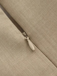 Detailed close-up of invisible zipper on beige twill dress showing premium craftsmanship