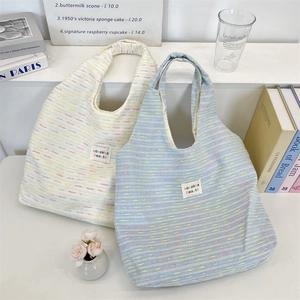 Detail of canvas tote bags with colorful stripe texture and sozakka beauté label