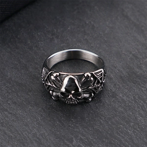 Detailansicht eines silbernen Totenkopfrings im Punk-Stil auf dunklem Steinhintergrund