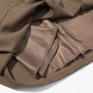 Gros plan sur le tissu tissé marron foncé avec doublure soyeuse et détails de couture précise
