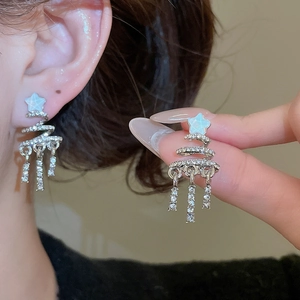Detail of silver Christmas tree tassel earrings with sparkling white rhinestones and star stud