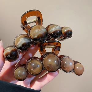 Detail of amber tortoiseshell acrylic hair claw clips with strong spring and marble texture