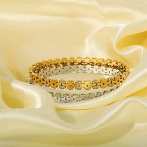 Polished gold and silver hollow chain bracelets with rhinestones on silk backdrop