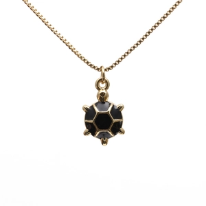 Minimalistische goldene Schildkröten-Halskette mit schwarzer Emaille auf weißem Grund