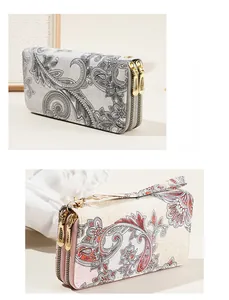 Close-up of double zipper paisley print wallets with wrist straps in vintage style