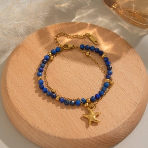 Dettaglio di un bracciale a doppio strato placcato oro 18K con perline blu e ciondolo stella