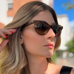 Vintage oval sunglasses with amber frames and brown gradient lenses for stylish women