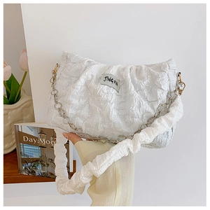 Detailed view of white pleated handbag with chain strap and ruched texture fabric