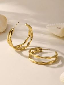 Vue détaillée des boucles d'oreilles créoles torsadées plaquées or 18k avec reflets
