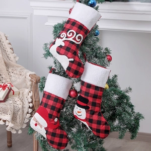 Three plaid Christmas stockings with 3D Santa, snowman, and reindeer on a tree branch