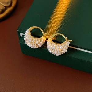 Detail view of French court style gold earrings with inlaid pearls and sparkling rhinestones