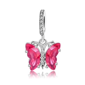 Detailed view of silver butterfly charm featuring red gemstones and diamond accents