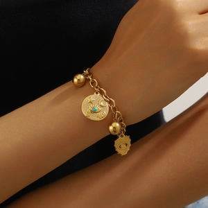 Gold chain bracelet with vintage celestial charms including eye, star and moon symbols