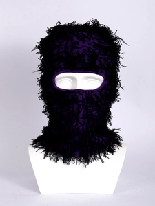 Detail of purple knitted balaclava with black tassels on a white mannequin head