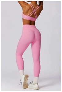 Detail of pink yoga set featuring cross-back sports bra and high waist leggings