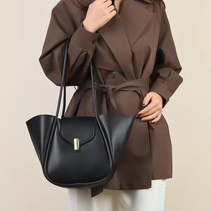 Sac fourre-tout chic en cuir noir avec fermoir doré et design latéral à ailettes