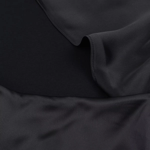 Gros plan d'un tissu satiné noir élégant montrant une texture lisse et brillante