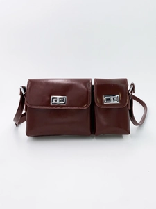 Detail of vintage brown leather crossbody bag with dual silver metal twist locks
