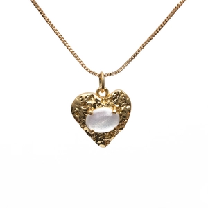 Golden heart pendant necklace with white stone inlay and hammer texture on white background