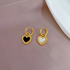 Detail of gold titanium steel heart earrings with black and white enamel inlays