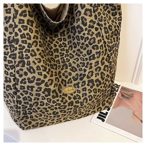 Detail of leopard print canvas tote bag with a metallic handmade label and fabric texture