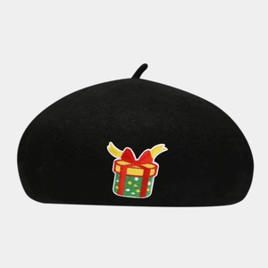 Close-up of black wool beret featuring a festive Christmas gift box embroidery detail